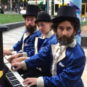 photo of Michael Chalk playing piano alongside Jules Chapple and Stevie, playing as "The Satin Dolls" during the Play Me I'm Yours festival in 2014